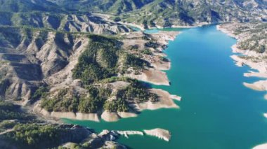 Kahramaras 'taki Ali Kayasi cam terasında yeşil tepeleri çevreleyen turkuaz suları ortaya çıkaran hava manzarası nefes kesici doğal manzara ve sakin manzara perspektifleri yakalıyor.
