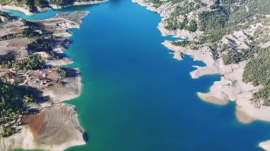 Ali Kayasi cam gözlem terasından nefes kesici bir manzara yükseliyor, menzelet baraj gölünün turkuaz sularını gözler önüne seriyor, Türkiye 'deki engebeli kahramanlık manzarasının arasına yerleşmiş.