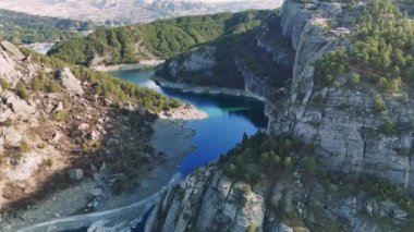 Turkuaz su kayalık uçurumlar ve bereketli yeşilliklerle dolu bir kanyondan geçiyor. Ali Kayasi cam terasında. Kahramanlar 'da popüler bir turizm merkezi.