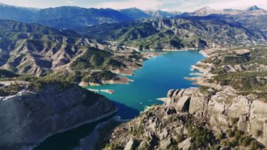 Alali kayasi cam terasını gözler önüne seren heybetli manzara. Yuvarlanan tepelerin ve kahramanmaraş 'taki görkemli dağların ortasındaki dingin göl manzarası. Hindi.