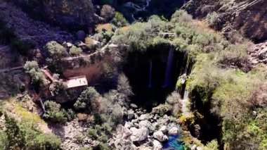 Salto del usero şelalesi derin, yemyeşil bir vadiye dalıyor, Bullas, murcia, İspanya 'da çarpıcı manzaralar sunan ahşap bir yürüyüş yolu ile pitoresk bir sahne oluşturuyor.