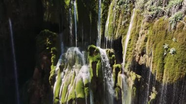 Saf su, canlı yeşil yosunlarla kaplı bir uçurumun üzerinden zarif bir şekilde akıyor. Bu da Türk topraklarında büyüleyici bir doğal manzara yaratıyor.