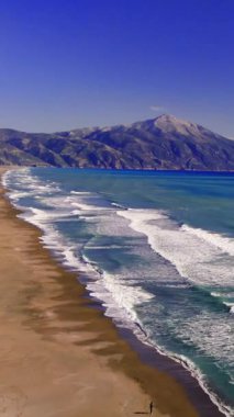 Turkuaz dalgalar el değmemiş kumlu kıyıları okşuyor, görkemli dağ çerçevesi huzurlu Akdeniz kıyı manzarası canlı, nefes kesici manzarası