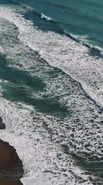 Okyanus dalgaları, zarif bir şekilde kıvrılıp kıyıya vururken büyüleyici bir dans yaratır. Ritmik hareketleri, doğal gücün rahatlatıcı bir senfonisidir.