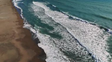 Okyanus dalgaları, zarif bir şekilde kıvrılıp kıyıya vururken büyüleyici bir dans yaratır. Ritmik hareketleri, doğal gücün rahatlatıcı bir senfonisidir.