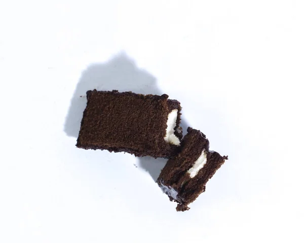 Çikolata soslu ve beyaz vanilyalı lezzetli çikolata tabakası süngeri. Beyaz arkaplana yakın açıdan çekilen fotoğrafta.