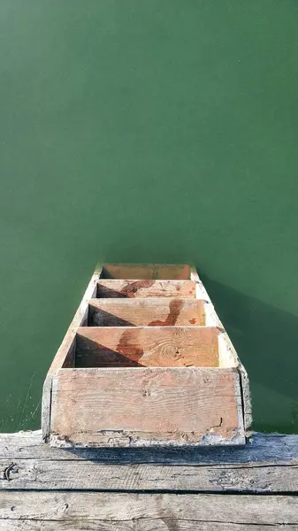 İyi inşa edilmiş ahşap bir merdiven, berrak gün ışığında huzurlu ve doğal bir ortamla çevrili, sakin yeşil sulara iniyor, keşifleri davet ediyor..