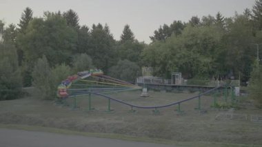 Lunaparktaki gezinti. Etrafı ağaçlarla çevrili. Akşam ışığı.