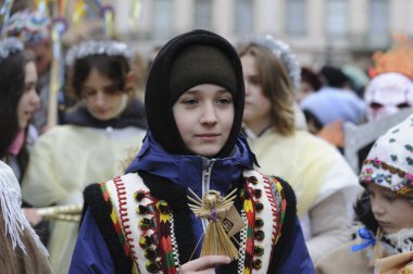 Lviv, Ukrayna 6 Ocak 2023. Ukraynalılar, Beytüllahim 'in büyük bir yıldızını ve Lviv şehir merkezindeki geçit töreninde ellerinde buğday demetlerini taşırken Noel şarkıları söylüyorlar. Ukraynalı inananlar Ortodoks Noel Gününü kutladılar