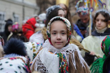 Lviv, Ukrayna 6 Ocak 2023. Ukraynalılar, Beytüllahim 'in büyük bir yıldızını ve Lviv şehir merkezindeki geçit töreninde ellerinde buğday demetlerini taşırken Noel şarkıları söylüyorlar. Ukraynalı inananlar Ortodoks Noel Gününü kutladılar