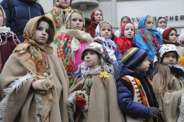 Lviv, Ukrayna 6 Ocak 2023. Ukraynalılar, Beytüllahim 'in süslü yıldızlarını taşırken ve Lviv şehir merkezindeki geçit töreninde ellerinde buğday demetleri taşırken Noel şarkıları söylüyorlar. Ukraynalı inananlar buna göre Ortodoks Noel Gününü kutladılar