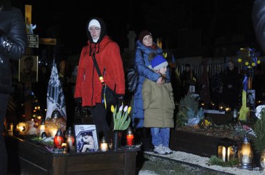 Lviv, Ukraine 23 feb 2023. Family members visit the graves of fallen soldiers in the Lychakiv cemetery where hundreds of Ukrainian soldiers who have died are buried during a commemoration event  'Rays of memory' were lit at the Lychakiv cemetery. 