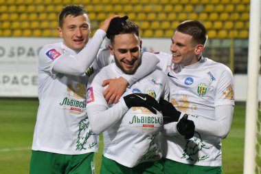 Lviv, Ukrayna. Vladyslav Klymenko (L), Ambrosiy Chachua (C), Karpaty 'li Oleg Ocheretko (R), FC Karpaty Lviv ile FC Veres Rivne arasında oynanan Ukrayna Premier Ligi maçında 7 Aralık 2024 tarihinde Ukrayna' nın başkenti Lviv 'de oynanan golü kutluyor..