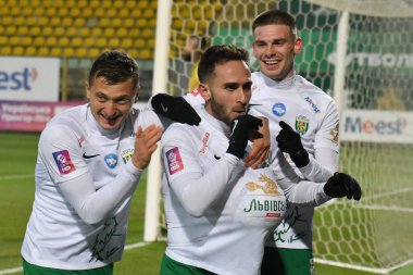 Lviv, Ukrayna. Vladyslav Klymenko (L), Ambrosiy Chachua (C), Karpaty 'li Oleg Ocheretko (R), FC Karpaty Lviv ile FC Veres Rivne arasında oynanan Ukrayna Premier Ligi maçında 7 Aralık 2024 tarihinde Ukrayna' nın başkenti Lviv 'de oynanan golü kutluyor..