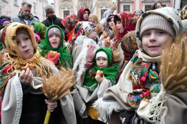 Lviv, Ukrayna 24 Aralık 2024. Geleneksel kostümler giymiş çocuklar bir Noel kutlaması sırasında dışarıda duruyorlar. Ukraynalılar Noel 'i geleneksel Julian takviminden uzaklaşarak Gregoryen takvimine göre kutluyorlar.