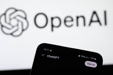 Lviv, Ukrayna 22 Şubat 2025. Bu resimde, arka planda OpenAI logosu olan bir akıllı telefondan bir ChatGPT logosu görüntülenmektedir. OpenAI, çeşitli sektörlerde geliştirmek için kullanılan araçlarla yapay zeka teknolojilerini geliştirmeye devam ediyor
