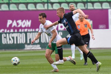 Lviv, UKRAINE - 30 Mart 2025. Ukrayna Premier Ligi FC Karpaty Lviv ve FC Chornomorets arasında oynanan 30 Mart 2025 tarihinde Ukrayna 'nın Lviv kentinde oynanan karşılaşmada Karpaty' den Bogdan Biloshevskyi 'ye karşı Karpaty' den Yan Kostenko. 