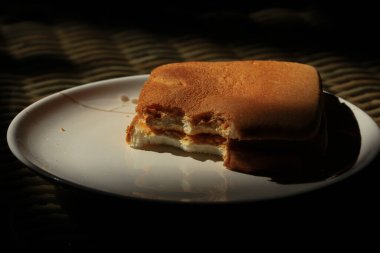 Sabah güneşinde beyaz bir tabakta tost ekmeği.