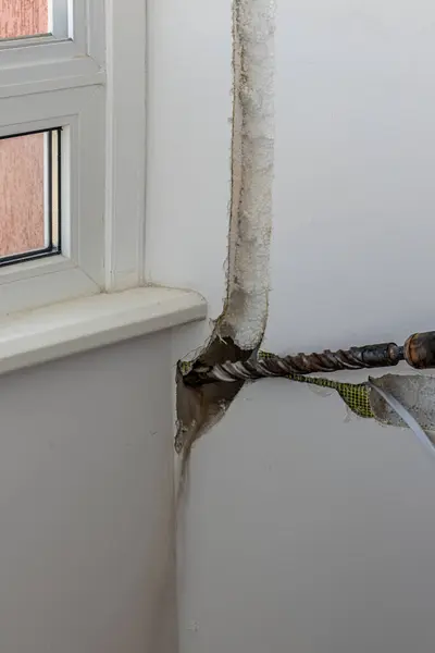 Klima sistemi teknisyeni yüksek kaliteli bir duvar sondajı yapıyor.