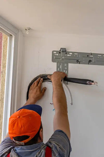 Installing an air conditioner in an apartment office, close-up of an engineer hand high quality photo