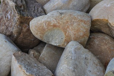 Pürüzsüz nehir taşlarının yakın çekimleri çeşitli sıcak tonlarda ve dokularda yüksek kaliteli fotoğraflar sergiliyor.