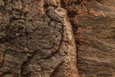Koyu kırmızı, kahverengi, çatlaklı kaya dokusu. Yakın çekim. Sert dağ yüzeyi. Tasarım için taş granit arka plan. Doğalcı