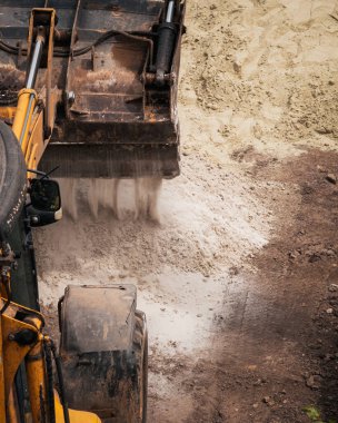 Traktör yüksek kaliteli fotoğraf doldurmak için kovalara kum getirdi.