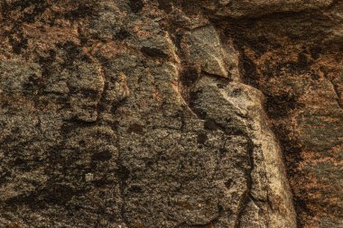 Koyu kırmızı, kahverengi, çatlaklı kaya dokusu. Yakın çekim. Sert dağ yüzeyi. Tasarım için taş granit arka plan. Yüksek kalite fotoğraf