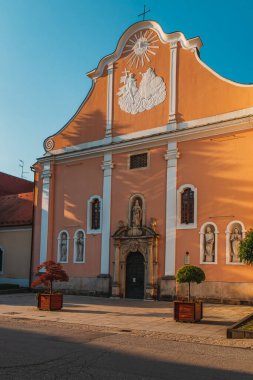 Varazdin 'deki şeftali rengi kilise. Barok mimarisi ve girişin üstünde çarpıcı bir fresk var.
