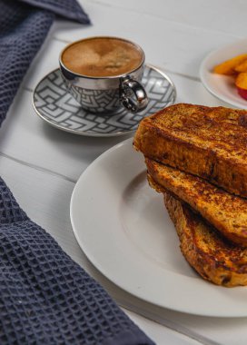 Kahvaltı için beyaz tabakta yumurtalı ekmek.