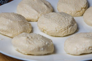 Kızartmadan önce beyaz tabakta süzme peynirli krep.