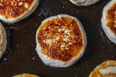 Kapatın. Süzme peynirli krepler, yüksek kaliteli fotoğraf çekilmeden önce tavada kızartılır.