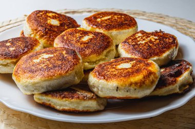 Beyaz tabakta taze kızarmış süzme peynirli gözleme.