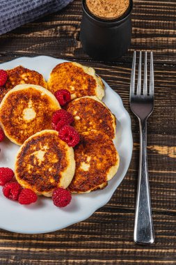 Masadaki beyaz tabakta taze ahududu ve süzme peynirli krep.