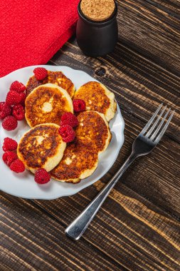Masadaki beyaz tabakta taze ahududu ve süzme peynirli krep.
