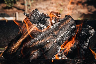 Bir kır evinde yanan odun yığınının içindeki yangının yakın plan görüntüsü.