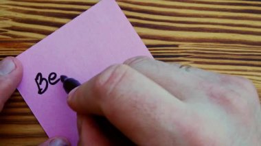 Bir adam, arka plandaki pembe bir kağıt parçasına yavaş çekimde mutlu olur. Yüksek kalite 4k görüntü