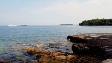 Huzurlu Kıyı Suları 'nda Rocky Shoreline ve Tranquil' in oynadığı Dalgalar görülüyor. Yüksek kalite 4k görüntü