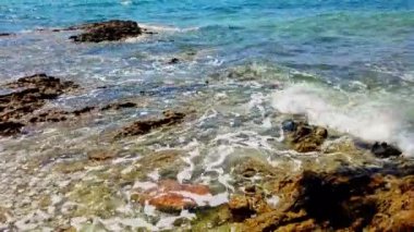 Huzurlu Kıyı Suları 'nda Rocky Shoreline ve Tranquil' in oynadığı Dalgalar görülüyor. Yüksek kalite 4k görüntü
