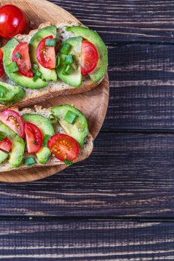 Avokado tostu domates ve yeşil soğanlı bir dilim havuçlu yüksek kaliteli fotoğraf.