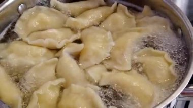 Bir adam köfteleri tencerede karıştırarak pişirir. Yüksek kalite 4k görüntü