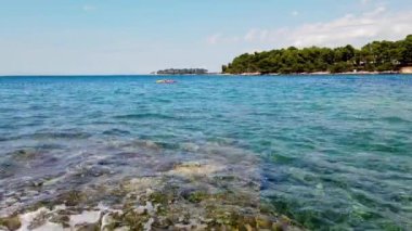 Huzurlu Kıyı Suları 'nda Rocky Shoreline ve Tranquil' in oynadığı Dalgalar görülüyor. Yüksek kalite 4k görüntü