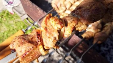Lezzetli marine edilmiş et şişleri dışarıda güneşin altında güneşlenirken mükemmelce ızgara yapıyor.