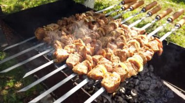 Cızırdayan kömür üzerinde pişen sulu ızgara et şişleri, toplanma, aile etkinlikleri ve açık hava yemekleri için ideal..