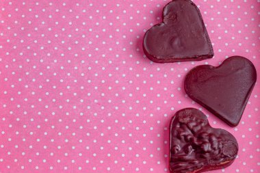 Pembe bir kutuda üç tane çikolatalı kalp, en kaliteli fotoğraf..