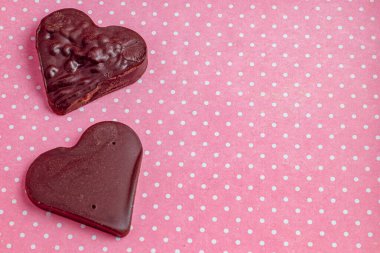 Sevgililer Günü fotoğrafı için pembe arka planda çikolata kalplerinin kompozisyonu.