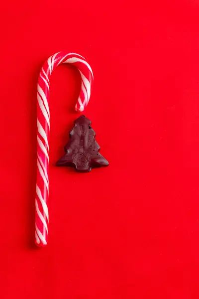 Noel kartı konsepti, lolipop ve kırmızı arka planda çikolata ağacı yüksek kaliteli fotoğraf.