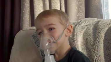 Sıcak ve rahat bir ev ortamında konforlu bir konumda iken nebulizör tedavisi gören bir çocuk