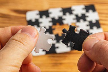 Siyah beyaz yapboz tutan eller, zor seçenek seçimi konsepti yüksek kaliteli fotoğraf.