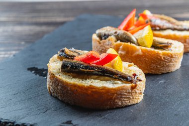 Masadaki taş tahtada üç balık sandviçi.